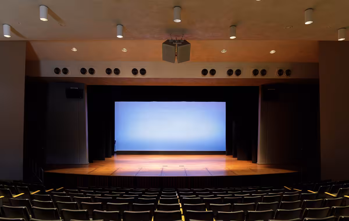 Empty Stage Auditorium with Lit Stage and Scrim